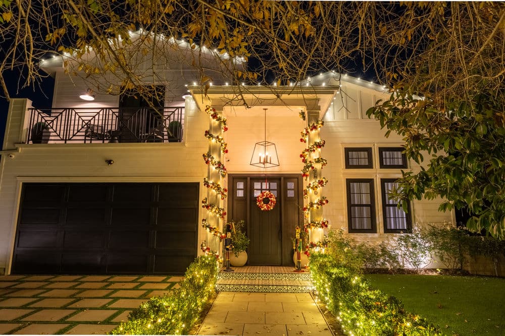 Festively decorated home exterior with lights and wreath, showcasing a welcoming entrance.